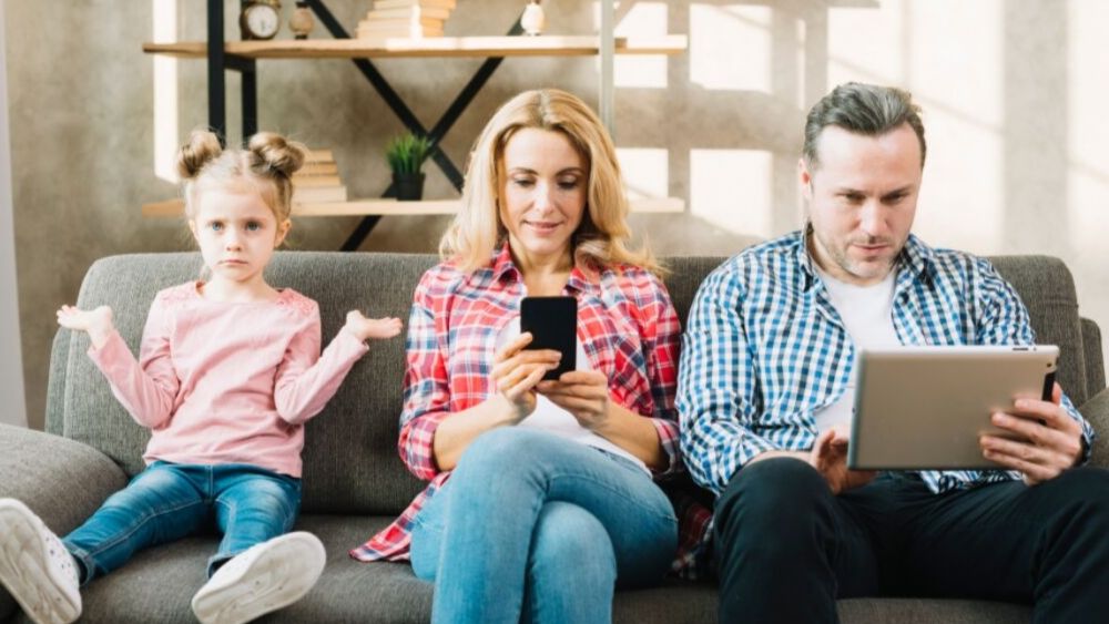 parents busy with phones in front of child